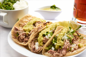 Pork or pork tacos, part that uses the knuckle and corn tortilla, prepared with xalapeño pepper sauce, cilantro and onion