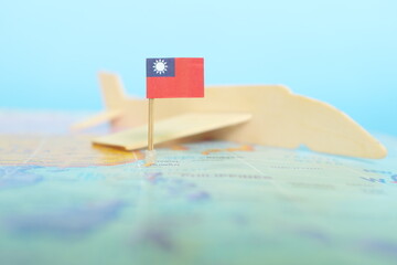 Selective focus of Taiwanese flag in blurry world map and wooden airplane model. Taiwan as travel...