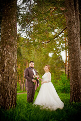 Wedding concept. Bride and groom in green park in a summer day