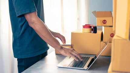 Shipment Online Sales .Man worker delivery service and working packing box, business owner working checking order to confirm before sending customer in post. Online selling, e-commerce Start up.