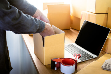 Young entrepreneur business owner work at home, small business startup receive order client and take note working with report and pack the product on purchase delivery online to sending destination.