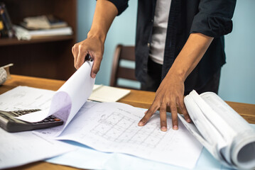 Architect working on blueprint. Architects workplace - architectural project, blueprints, ruler, calculator, laptop and divider compass. Construction concept. Blue print is fake only for stock photo.