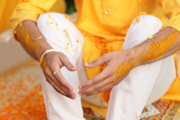 groom hands in turmeric paste in haldi ceremony 