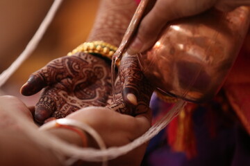 Hands of Hindu Bride and Groom In White Thread in kanyadaan Ceremony and Apply Water On Hands