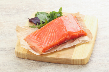 Raw salmon fillet over board