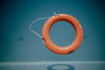 in the blue water of a swimming pool floats one red life ring