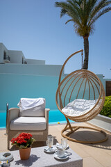 next to a swimming pool are some armchairs for relaxing