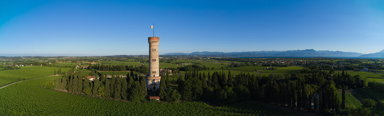 Fototapeta na wymiar Aerial panorama of Tower of San Martino della Battaglia, italy. Aerial view of the tower on Lake Garda. Tower surrounded by vineyards drone view.