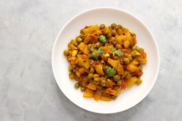 Aloo Matar curry. Potato, Peas cooked with an Onion and Tomatoes along with Indian spices. Garnished with coriander leaves. Served with chapati or bhakri. Copy space