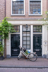 Fototapeta na wymiar Amsterdam house, red brick facade, bicycle parked outside, residential neighborhood, Holland