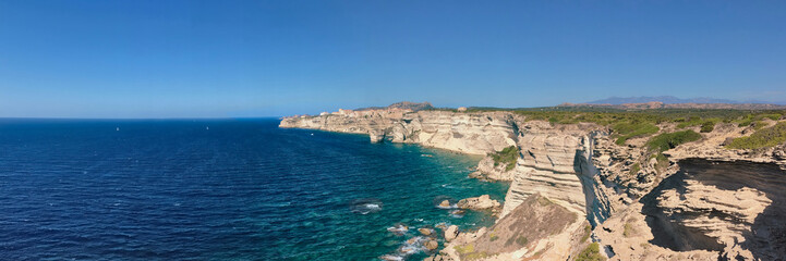 Bonifacio- Corsica coastline with limestone cliff overlooking the sea on clear blue sky.