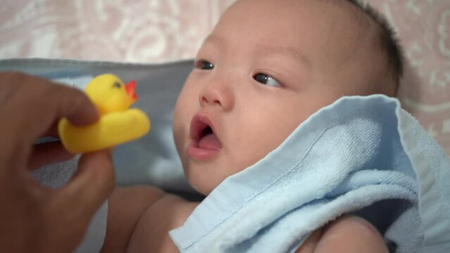 POV view infant curious with rubber duck toy