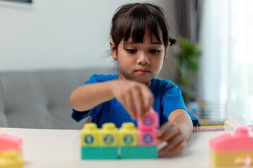 Asian child girl playing creative toy blocks for homeschooling