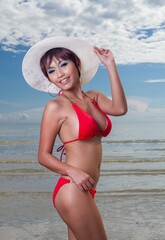 Sexy asian red bikini female lady model having a great holiday by a beach and posing  happily with different enjoy look and moment, suitable for glamour travel summer ads 