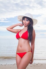 Sexy asian red bikini female lady model having a great holiday by a beach and posing  happily with different enjoy look and moment, suitable for glamour travel summer ads 