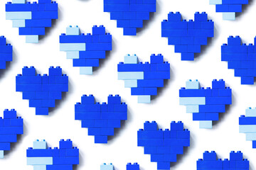 Blue hearts from blocks isolated on white background, minimal geometric pattern from bricks, shapes heart from child construction. Wallpaper of plastic blocks, repeat pattern