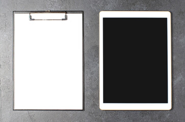 A clipboard with a sheet of paper for writing. Black concrete background
