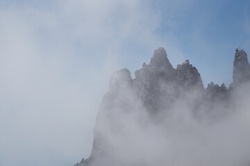 Clouds cover the rocky summit. Rocky Mountains.