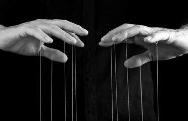 Man hands with strings on fingers. Manipulation, control, power, abuse concept. Black and white....