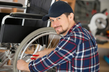man is fixing a wheelchair