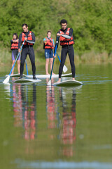 people on a stand up paddle board paddeling