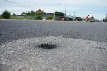 Holes drilled to measure the thickness of asphalt roads, 4 inches wide.