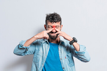 Man with nasal bridge headache, person with pain touching nose. sinus pain concept, A person with...