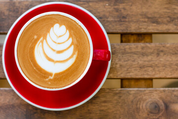 Red cup of coffee on wood table