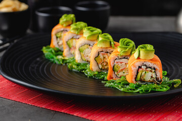 Sushi set of various products on a black stone plate. Blur background and selective focus