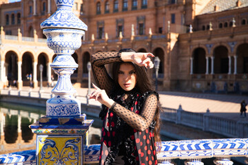 Young and beautiful typical Spanish woman dancing flamenco with urban and modern clothes, wearing...