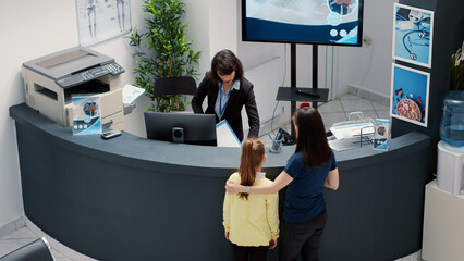 Busy hospital reception with many people waiting to write report for checkup visit appointment....