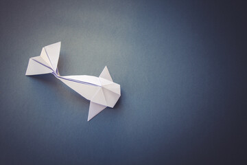 White paper fish origami isolated on a grey background