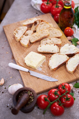 pieces of sliced baguette with spread butter on wooden board