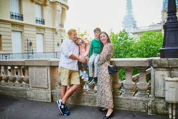 Obraz premium Happy family of four enjoying their trip to Paris, France