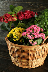 Wicker basket with flowers on wooden table
