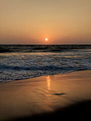 Beautiful orange sunset over the sandy beaches of Goa, India
