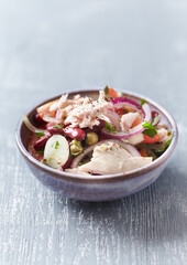 Salad with tuna and cherry tomatoes. Wooden background. Close up. Copy space.