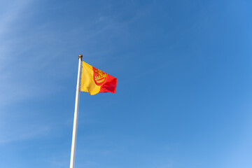 The flag of the Lithuanian port city of Klaipeda flies against the background of a blue clear cloudless sky