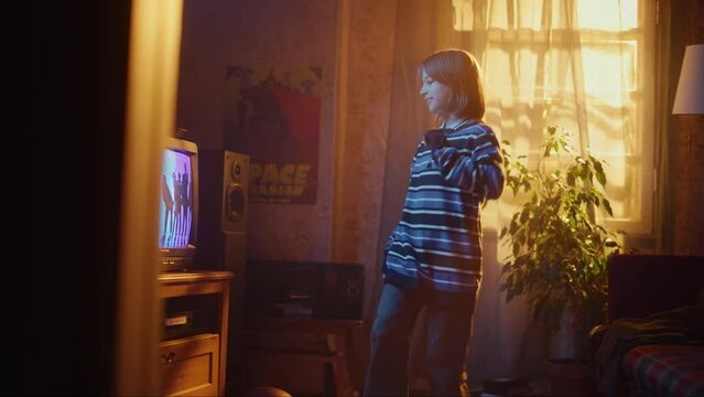 Nostalgic Retro Childhood Concept. Young Girl Dancing to Music Video on TV Channel in Her Room with Dated Interior. Excited Kid Repeat Dance Moves Dancers Perform in the Video.