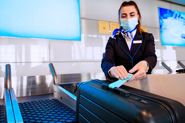 Airport ground staff sits at the counter, weighing luggage and registration