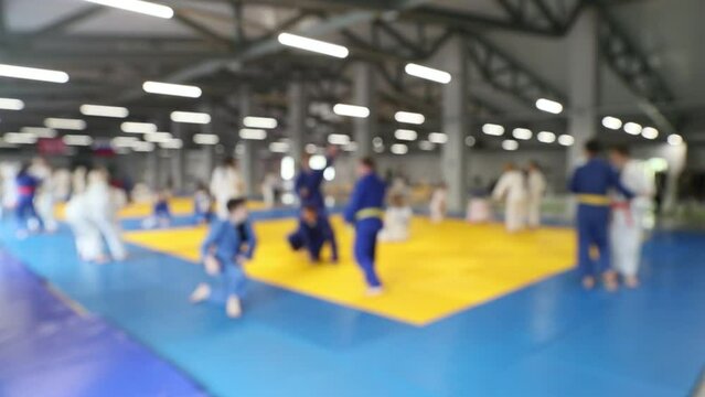 teenagers in kimono doing judo warm-up blurred focus
