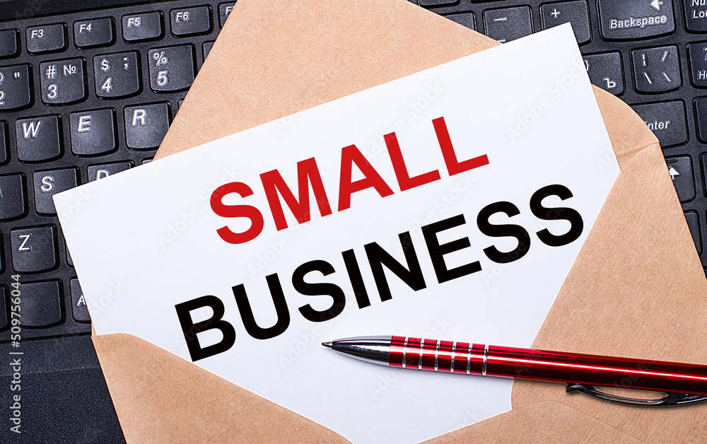 Poster white card with the text small business in a craft envelope on a work desk with a modern laptop keyb