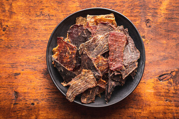 Beef jerky meat. Dried sliced meat in plate. - obrazy, fototapety, plakaty