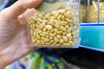 Packaged snacks pine nuts on the shelves of the hypermarket. A healthy snack. Selective focus