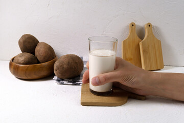 Alternative vegetable vegan potato milk in a glass and potato. Vegetarian food. Alternative non...
