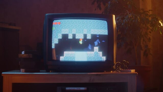 Close Up Footage of a Retro TV Set Screen with an Eight Bit Eighties Inspired Console Arcade Video Game. Quest Loading, Player Kills a Monster, Collects Hearts and a Treasure Chest, and Wins.