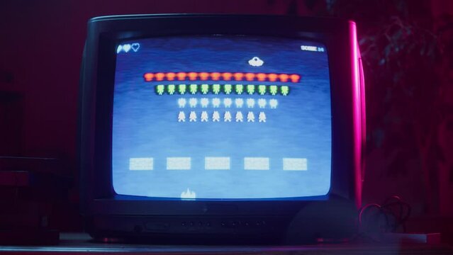 Close Up Footage of a Retro TV Set Screen with an 8 Bit 2D Eighties Inspired Console Arcade Video Game. Nostalgic Space Shooter Game, Player Battle with Swarm of Aliens and Wins.