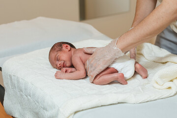 Physiotherapist performing an evaluation on the spine of a newborn baby.