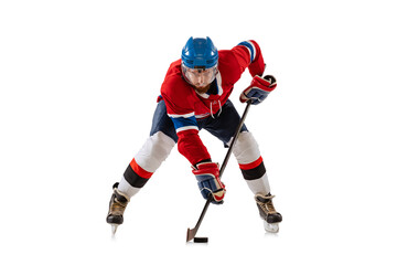 Young male hockey player in sports uniform and protective equipment training isolated on white...