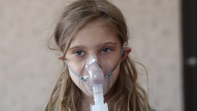 home environment. a girl with white hair is breathing through a medical mask. inhaler for cough and respiratory relief